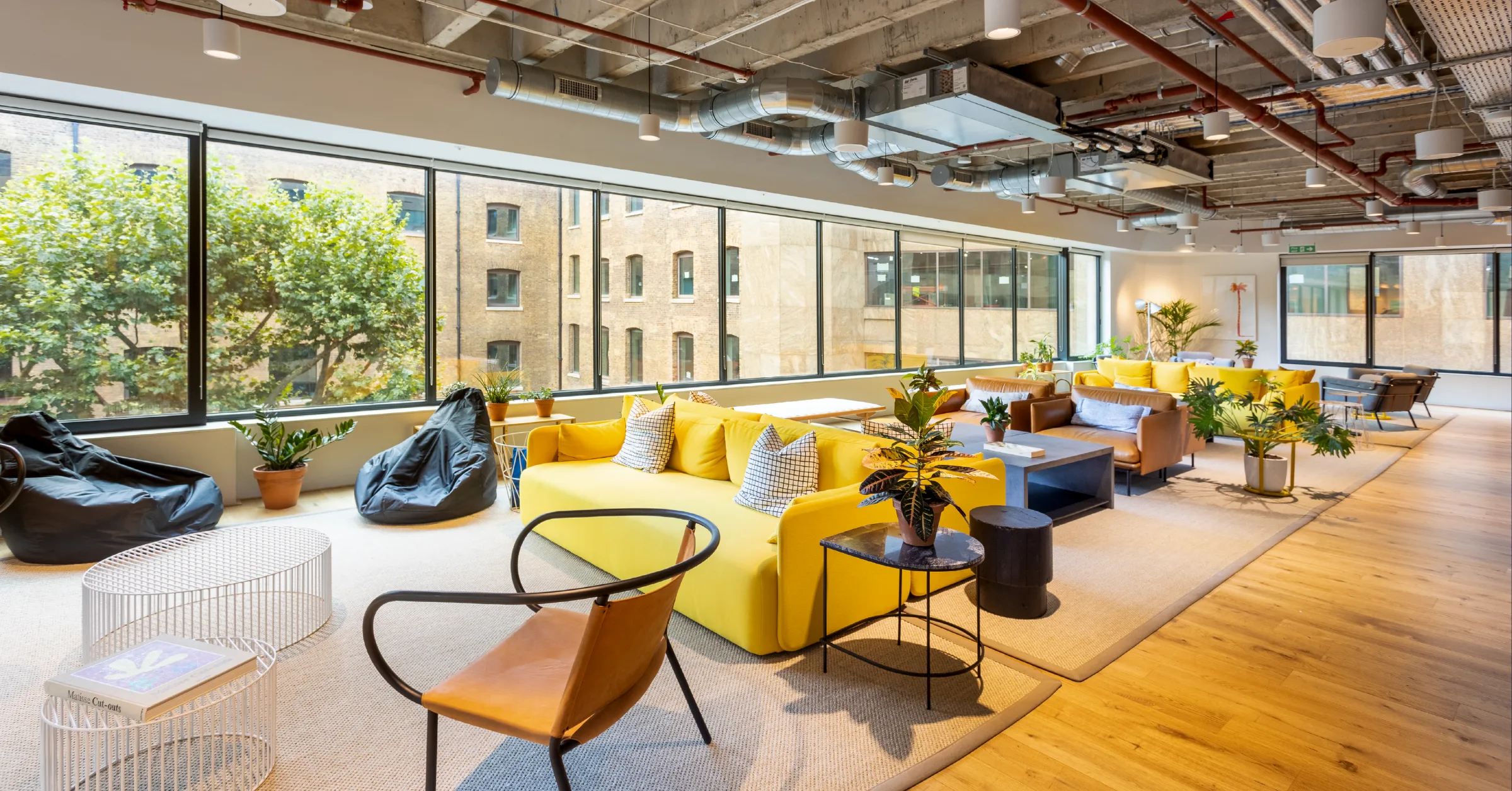 The office lounge, with yellow sofas and floor-to-ceiling windows